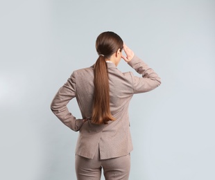 Photo of Young woman on grey background, back view