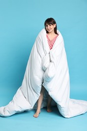 Happy woman with pyjama wrapped in blanket