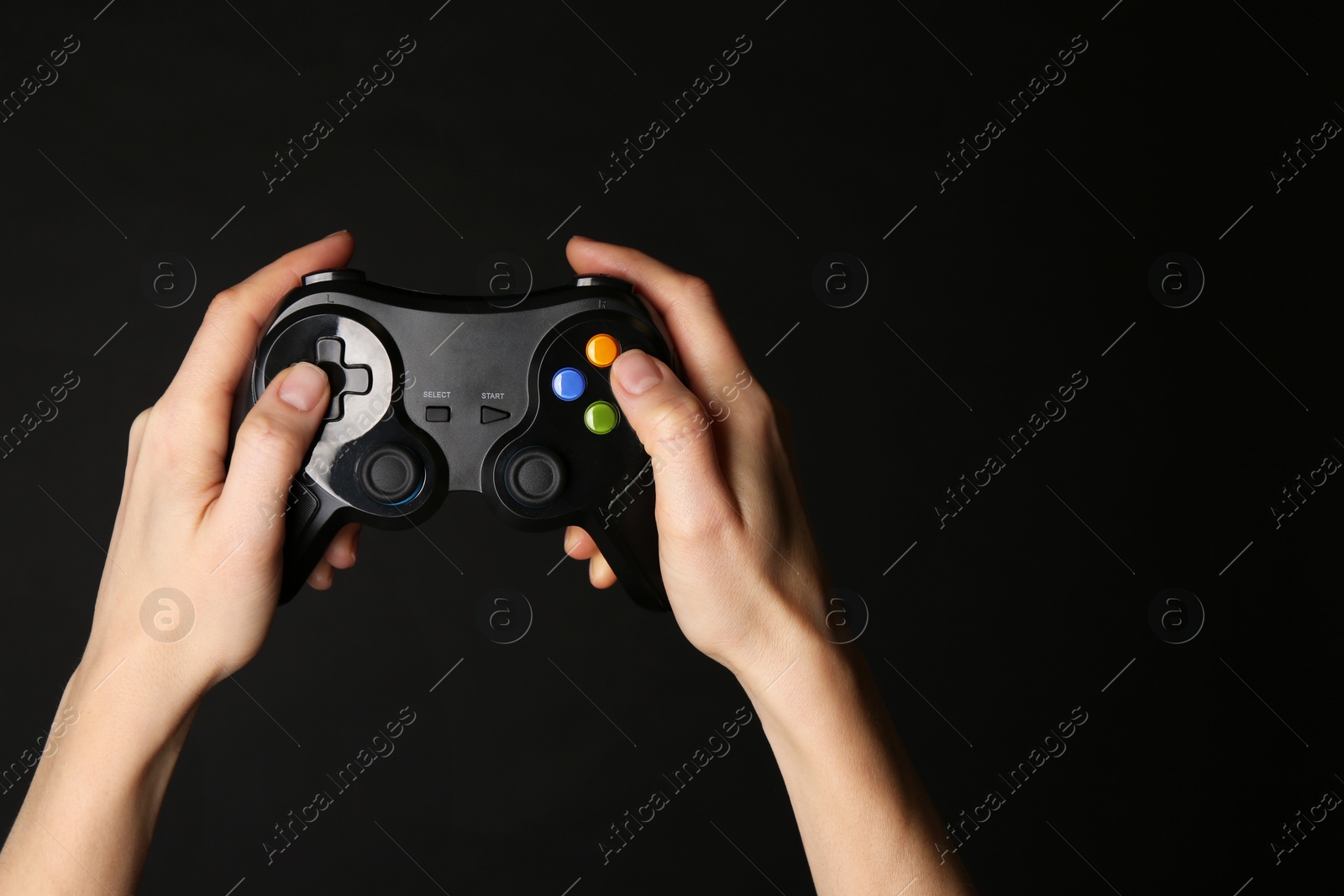 Photo of Woman using game controller on black background, closeup. Space for text