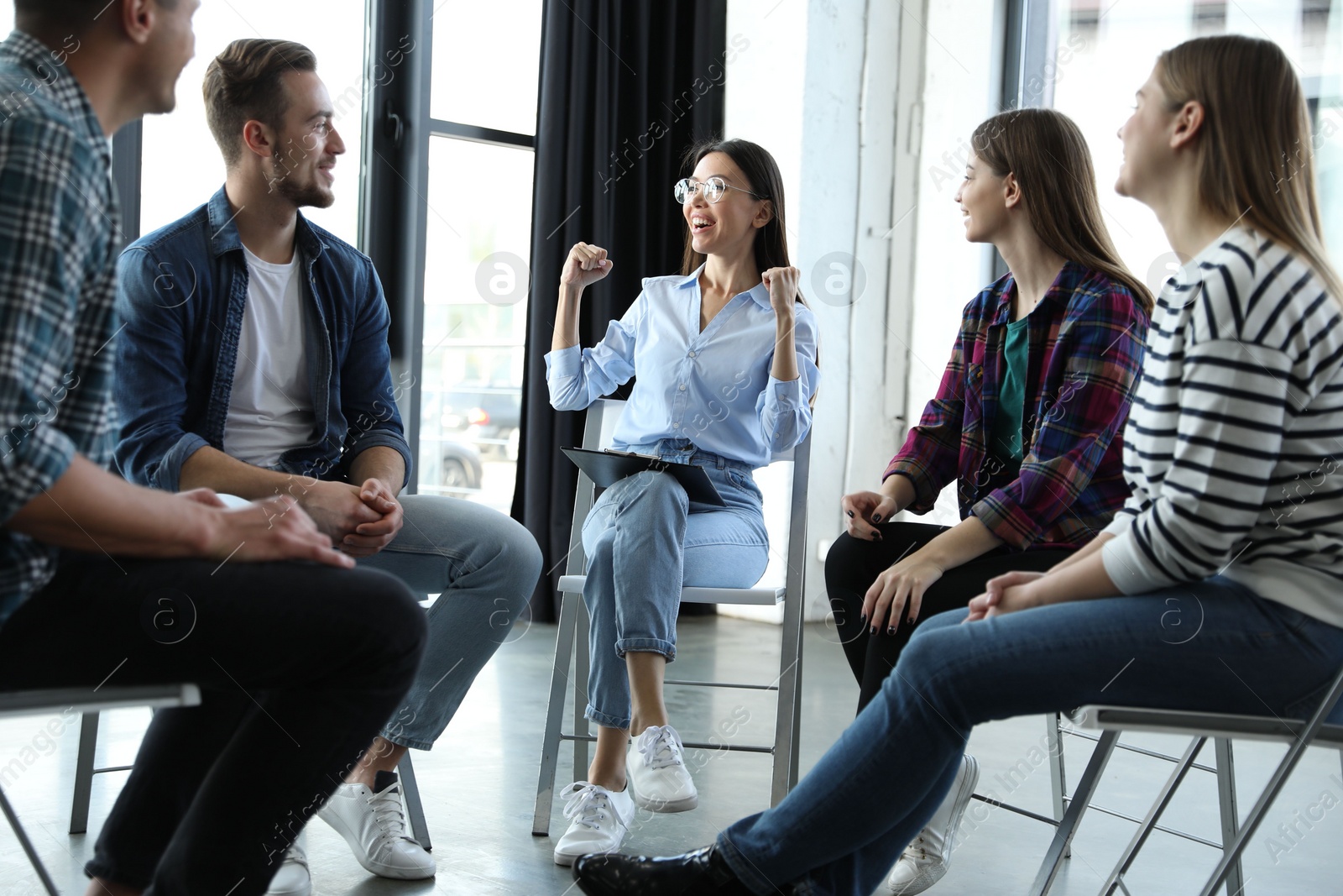 Photo of Psychotherapist working with patients in group therapy session indoors