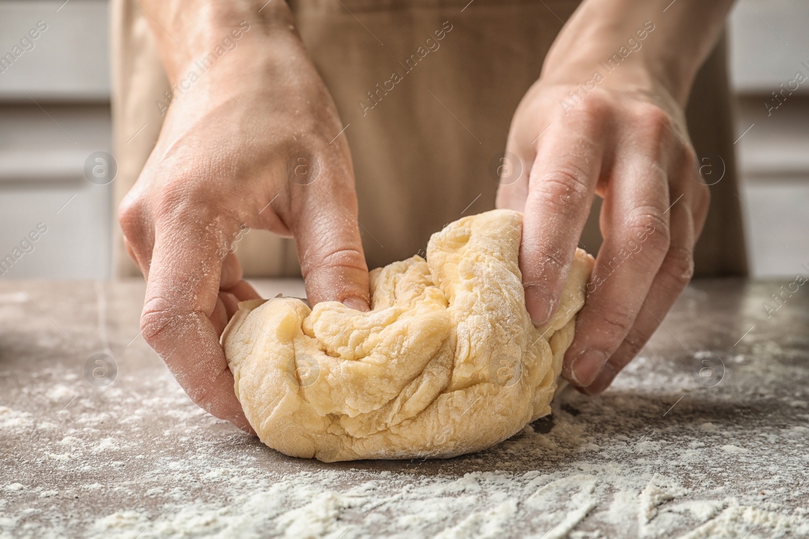 Photo of Woman kneading dough for pasta at table
