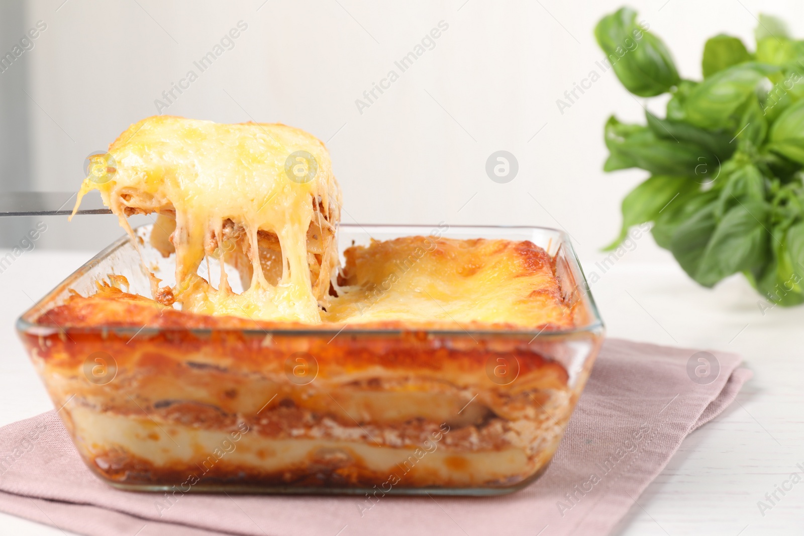 Photo of Delicious lasagna in baking dish on white table