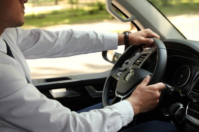 Man driving his car, closeup view of hands on steering wheel