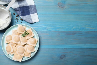 Photo of Homemade uncooked ravioli on blue wooden table, flat lay. Space for text