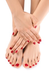Photo of Woman showing stylish toenails after pedicure procedure and manicured hands with red nail polish isolated on white, top view