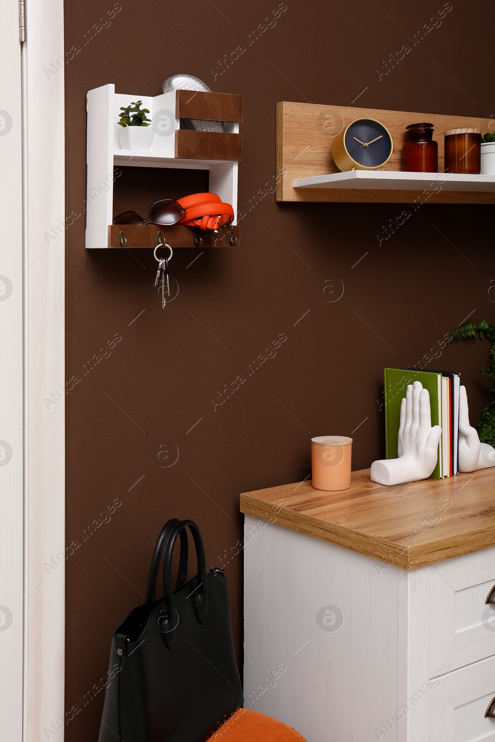 Photo of Stylish hanger for keys on brown wall in hallway