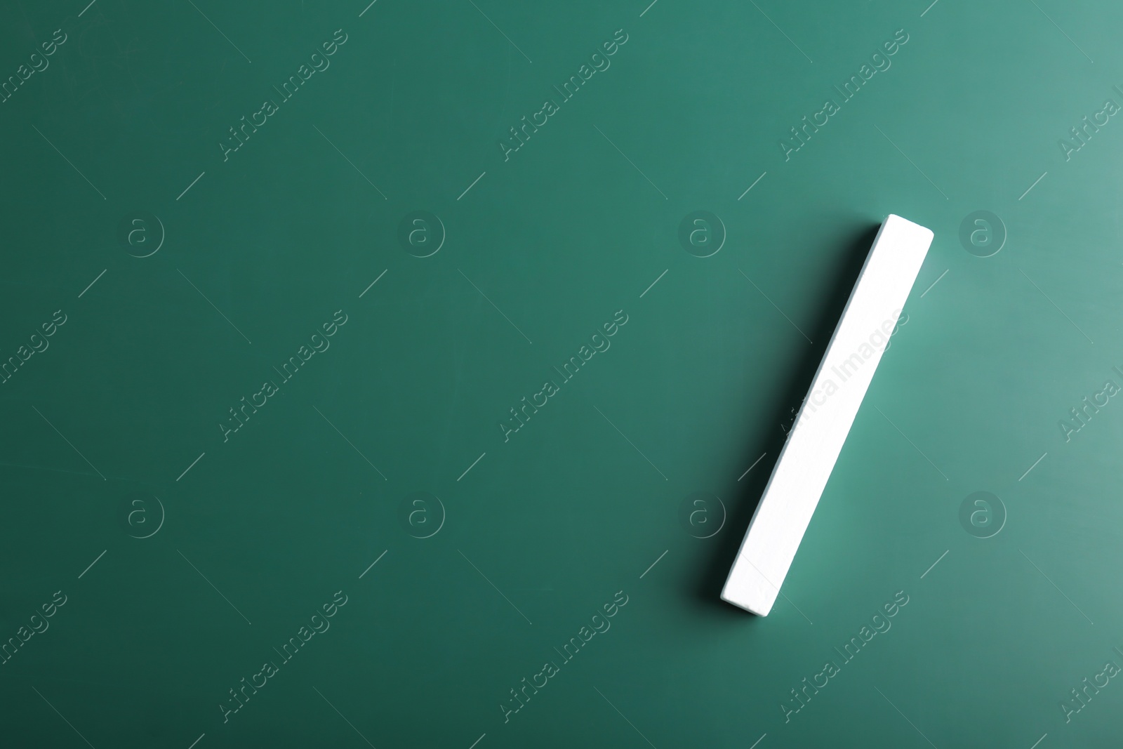 Photo of Piece of chalk on green background, top view