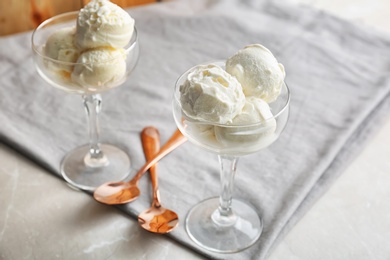 Photo of Bowls with tasty vanilla ice cream on table