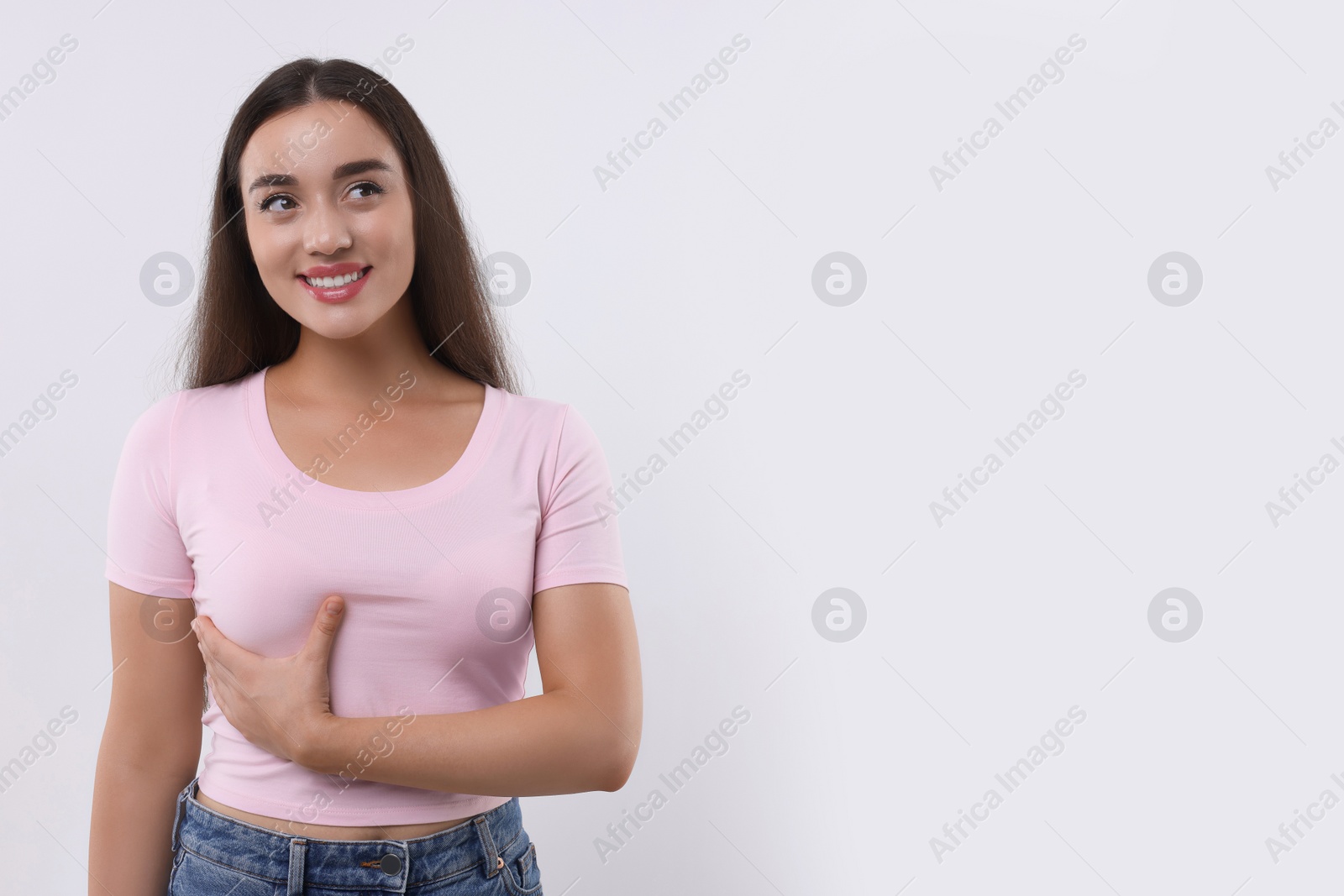 Photo of Beautiful happy woman doing breast self-examination on white background, space for text