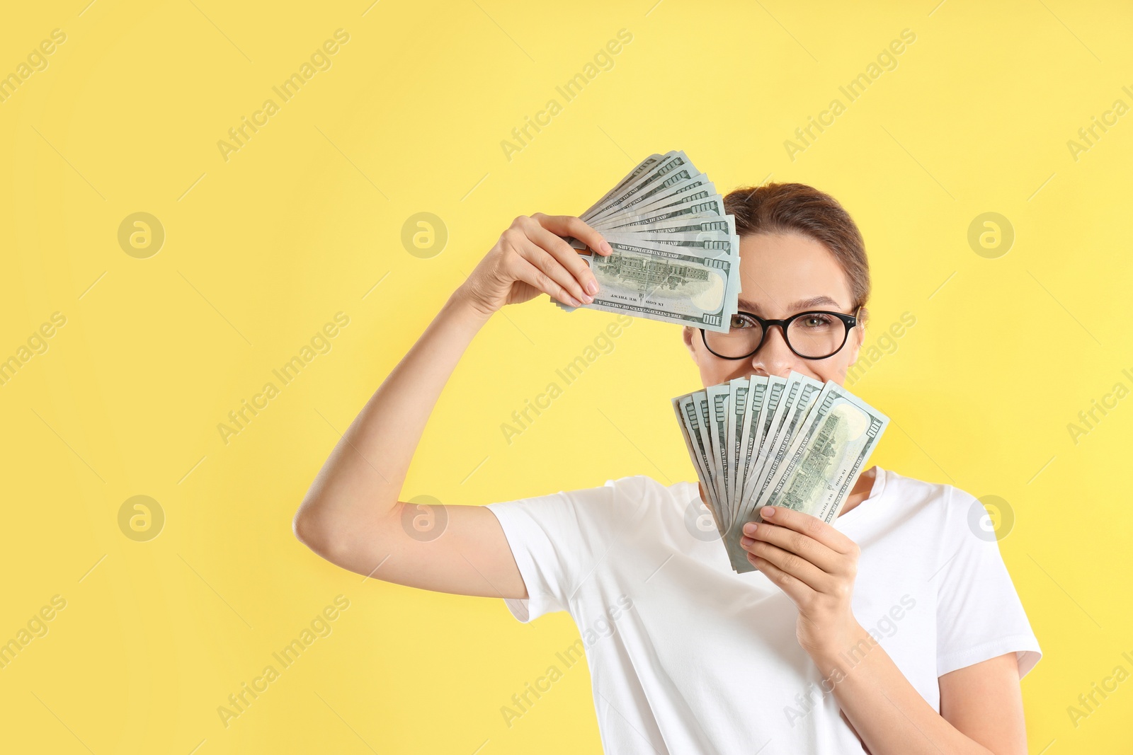 Photo of Young woman with money on yellow background