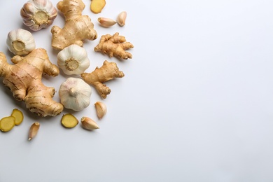 Photo of Ginger and garlic on white table, flat lay with space for text. Natural cold remedies