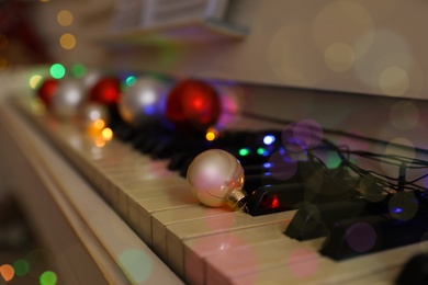 Photo of Bauble on piano keys indoors, closeup. Christmas music