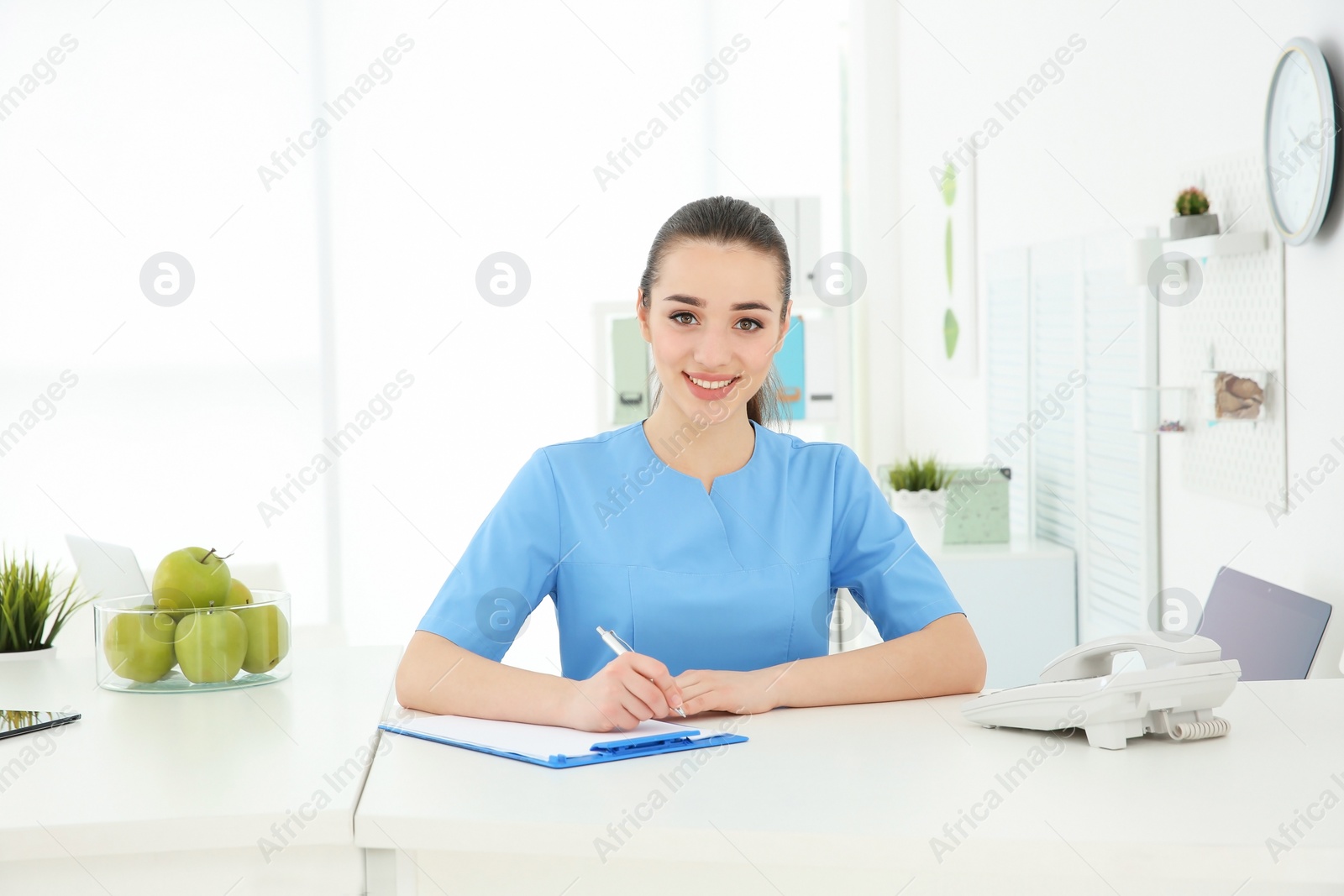 Photo of Young female receptionist working in hospital