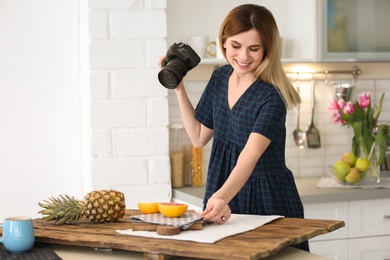 Photo of Young blogger taking photo of food in kitchen