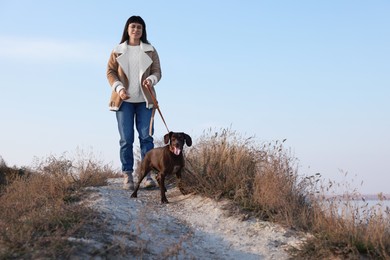 Photo of Woman with her German Shorthaired Pointer dog walking outdoors