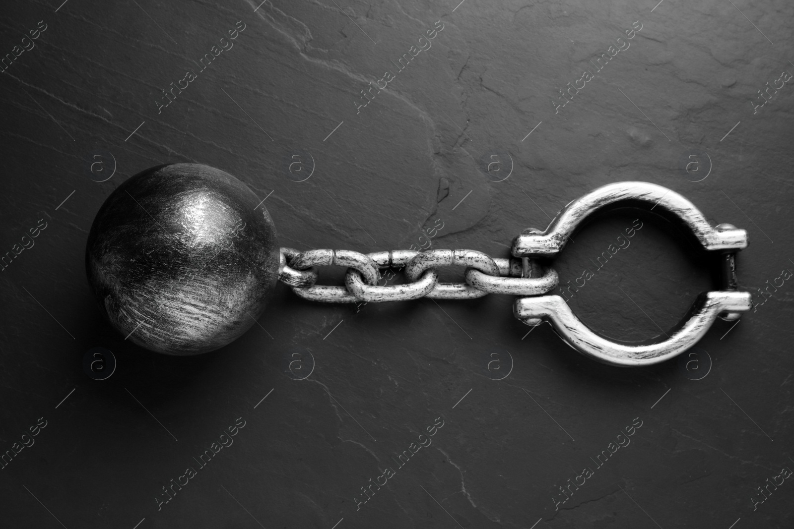 Photo of Prisoner ball with chain on black table, top view