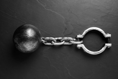 Prisoner ball with chain on black table, top view