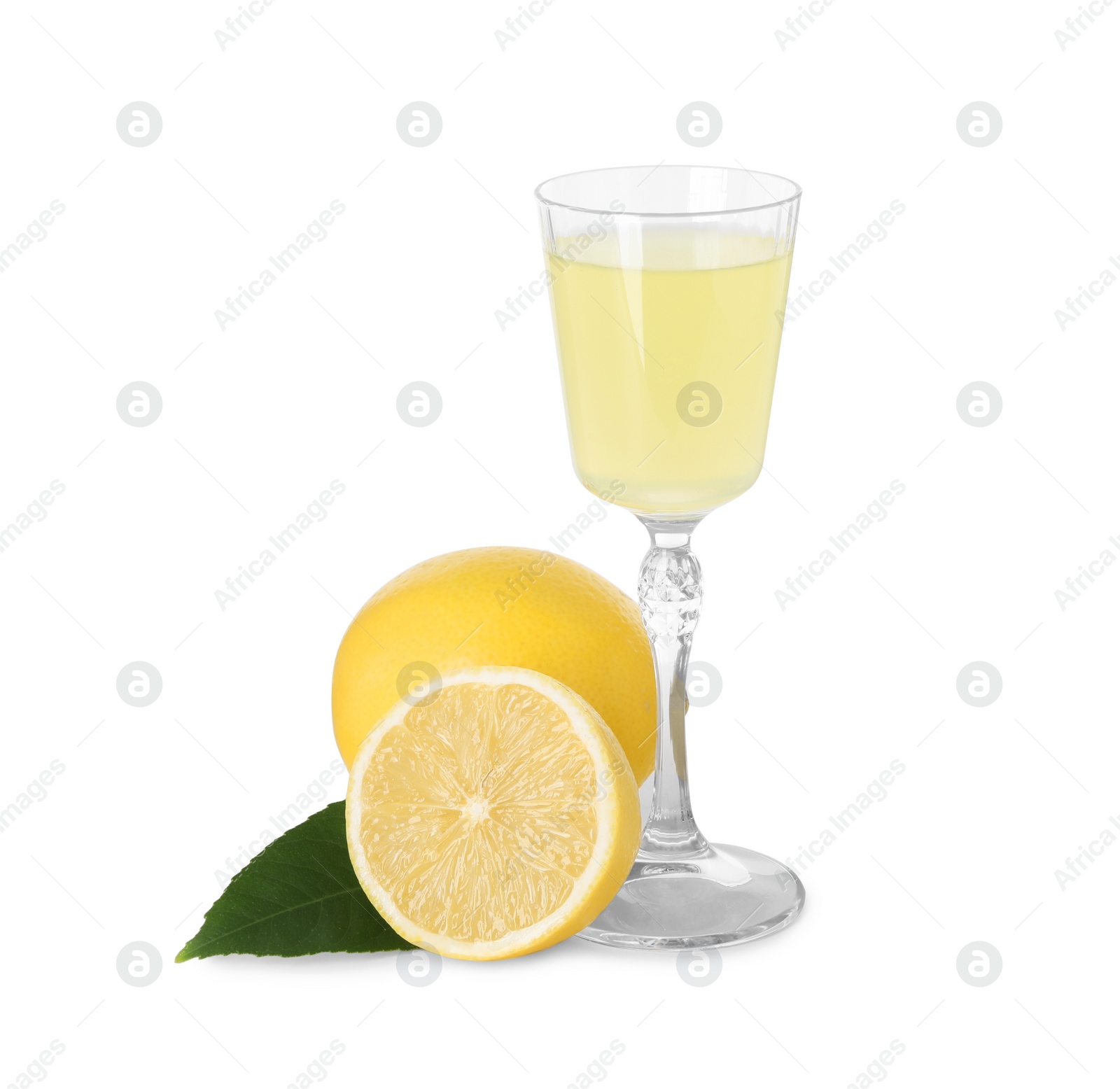 Photo of Liqueur glass with tasty limoncello, lemons and green leaf isolated on white