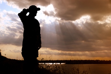 Photo of Soldier in uniform saluting outdoors. Military service