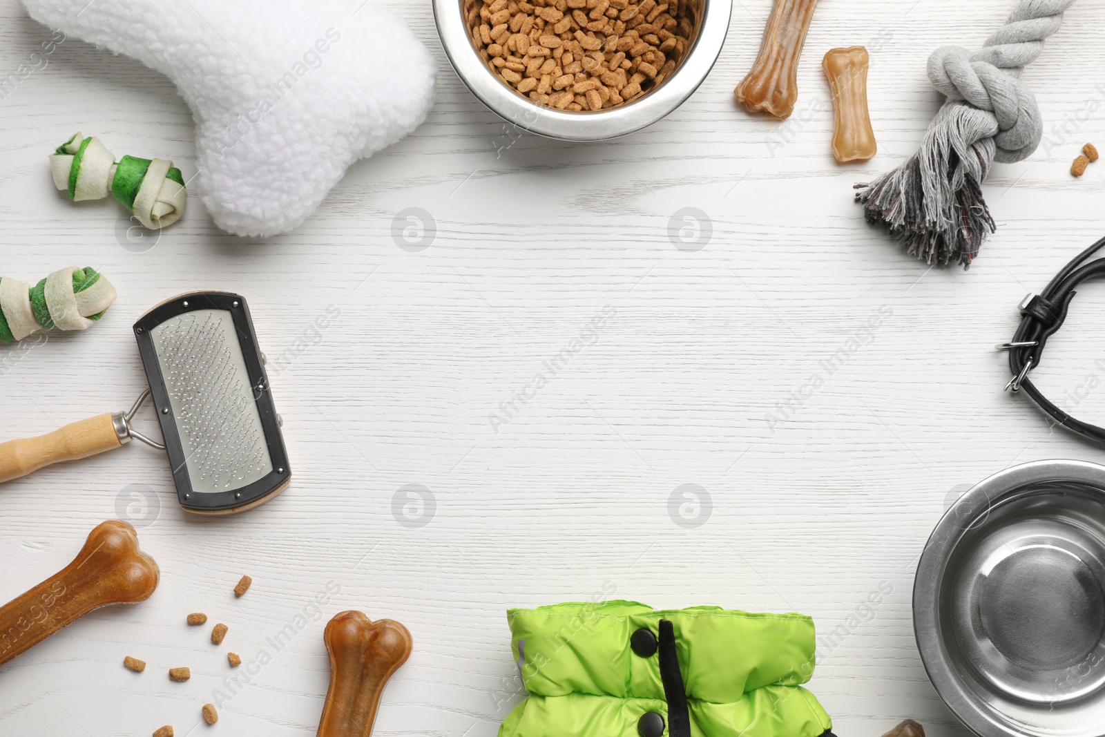 Photo of Flat lay composition with dog clothes, food and accessories on white wooden table. Space for text