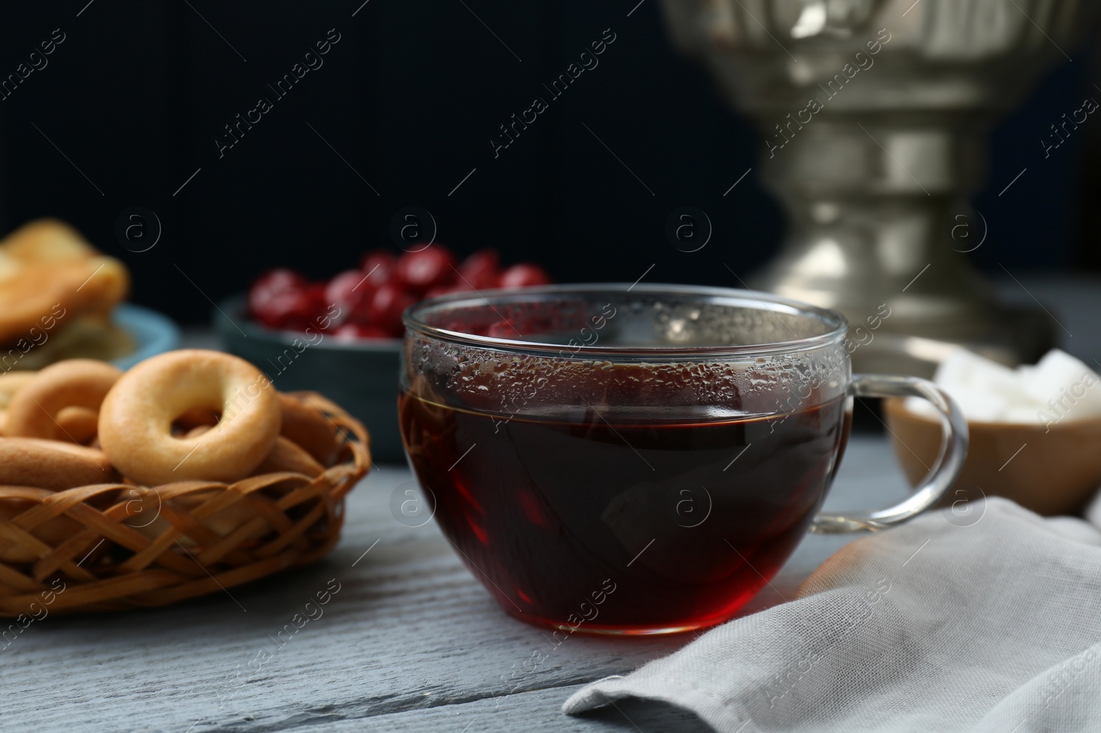 Photo of Glass cup of aromatic tea on light blue wooden table