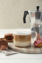 Photo of Aromatic coffee in cup, tasty macarons, eclair and moka pot on white wooden table