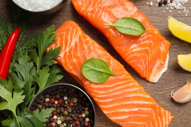 Photo of Fresh salmon and ingredients for marinade on wooden table, flat lay