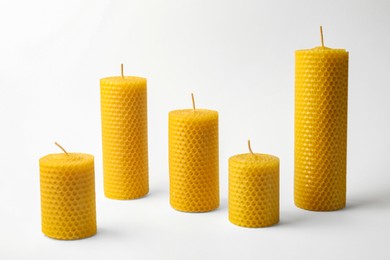 Photo of Stylish elegant beeswax candles on white background