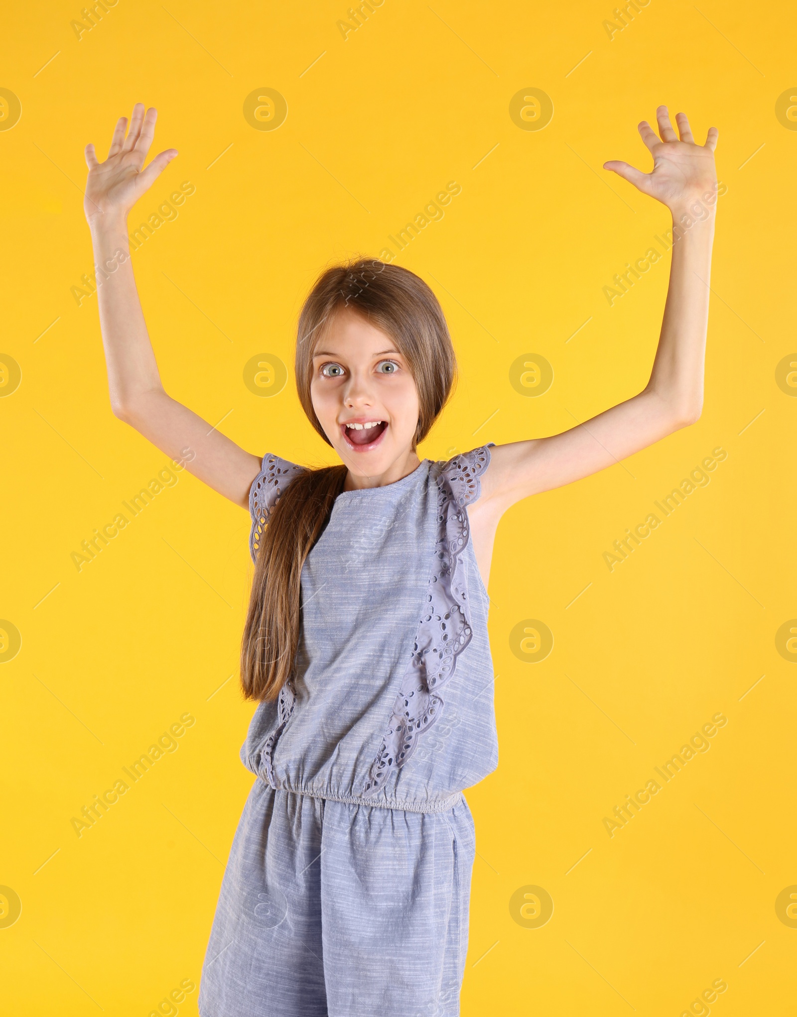 Photo of Portrait of emotional little girl on yellow background