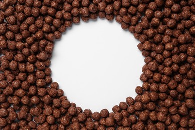 Frame of sweet crispy chocolate corn balls on white background, top view. Space for text