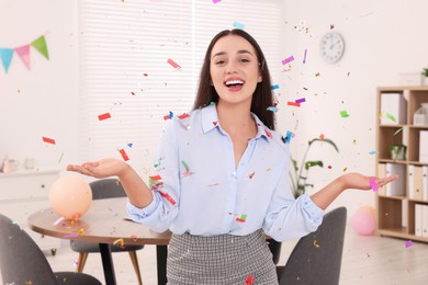 Photo of Young woman having fun during office party indoors