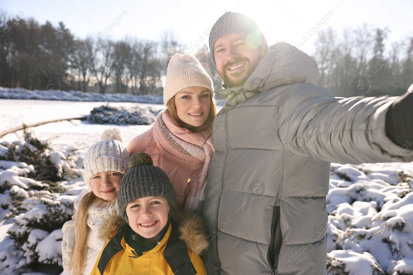 Photo of Happy family taking selfie in sunny snowy park