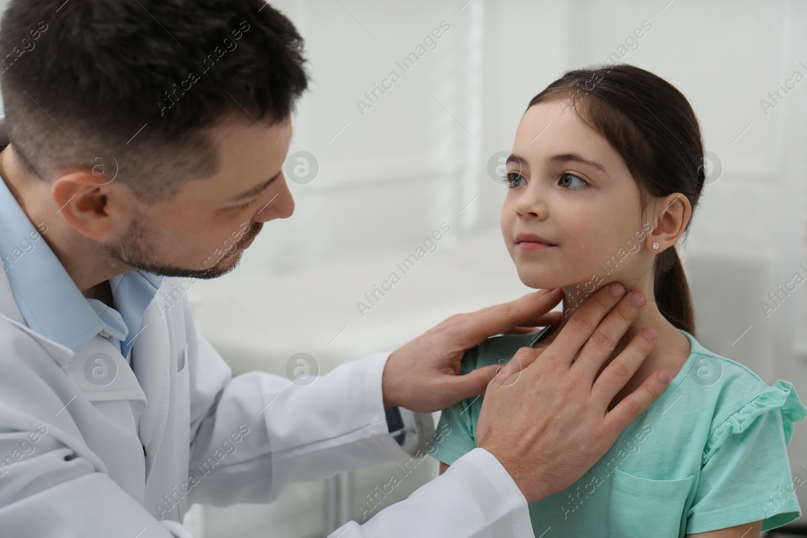 Photo of Pediatrician examining little girl in office at hospital