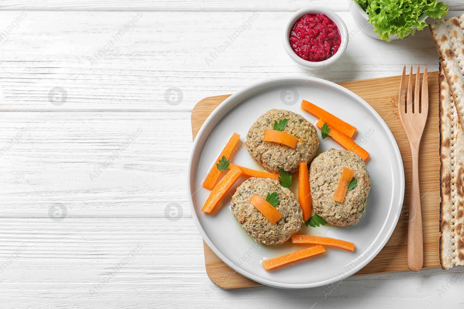 Photo of Flat lay composition with plate of traditional Passover (Pesach) gefilte fish on wooden background. Space for text