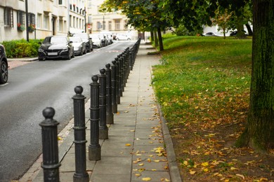 Photo of Beautiful view of sidewalk path near road with cars outdoors. Footpath covering