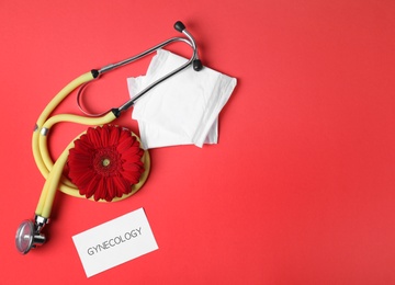 Photo of Card with word Gynecology, stethoscope, pads and flower on color background, flat lay. Space for text