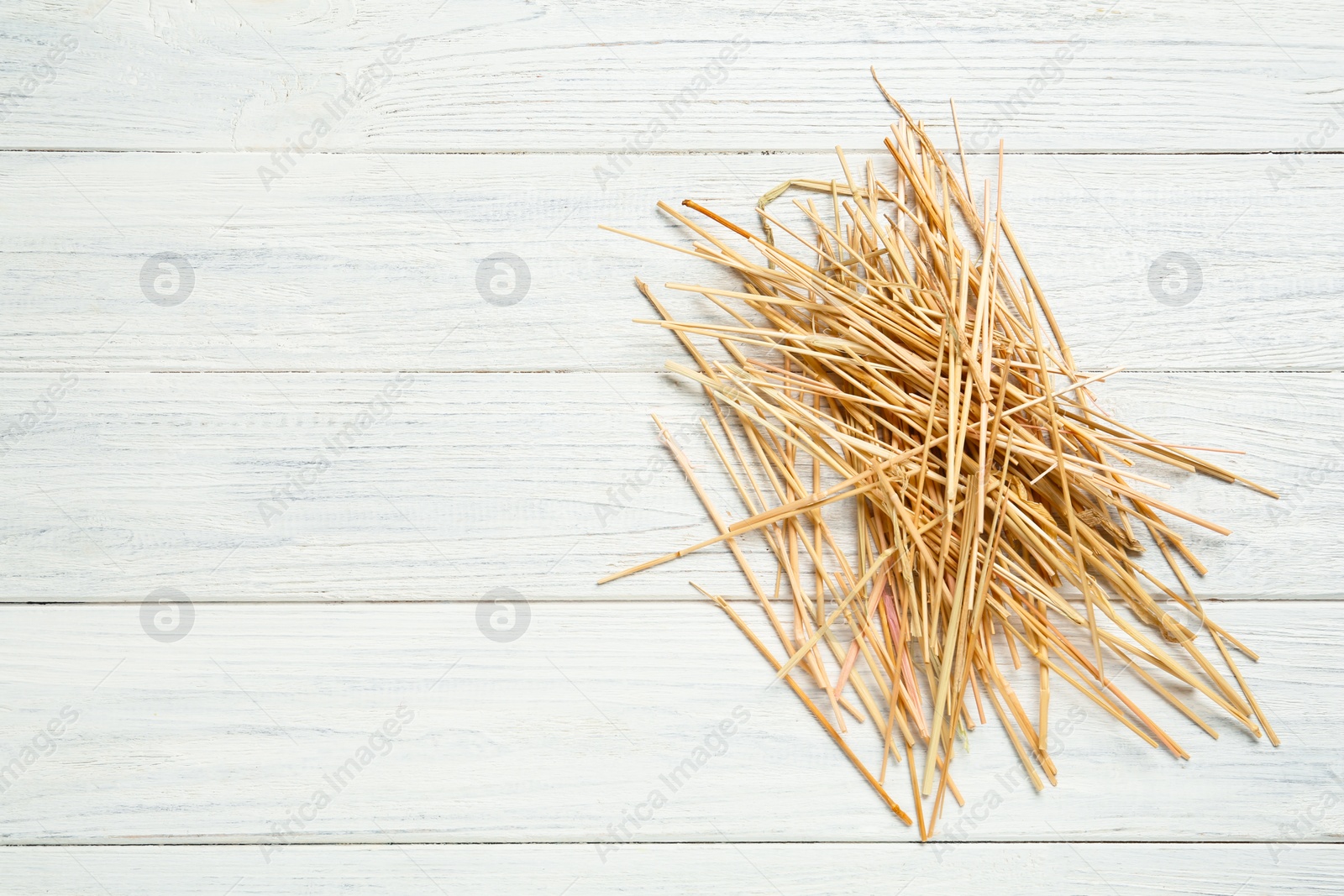 Photo of Dried hay on white wooden background, top view. Space for text