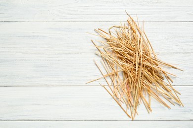 Dried hay on white wooden background, top view. Space for text