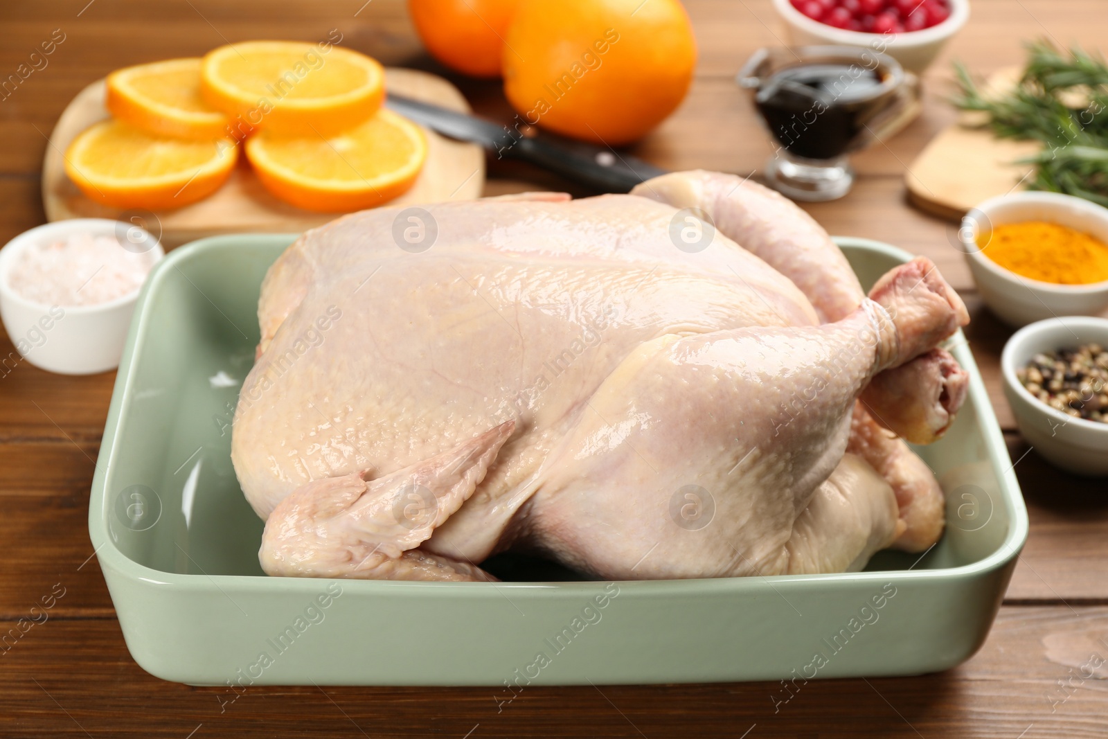 Photo of Raw chicken and orange slices on wooden table