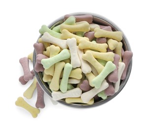 Photo of Different bone shaped dog cookies and feeding bowl on white background, top view