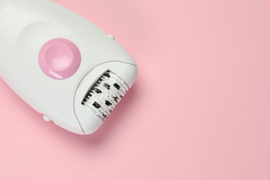 Modern epilator on pink background, top view. Space for text