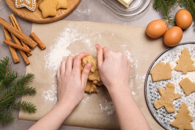 Making Christmas cookies. Woman kneading dough at grey table, top view