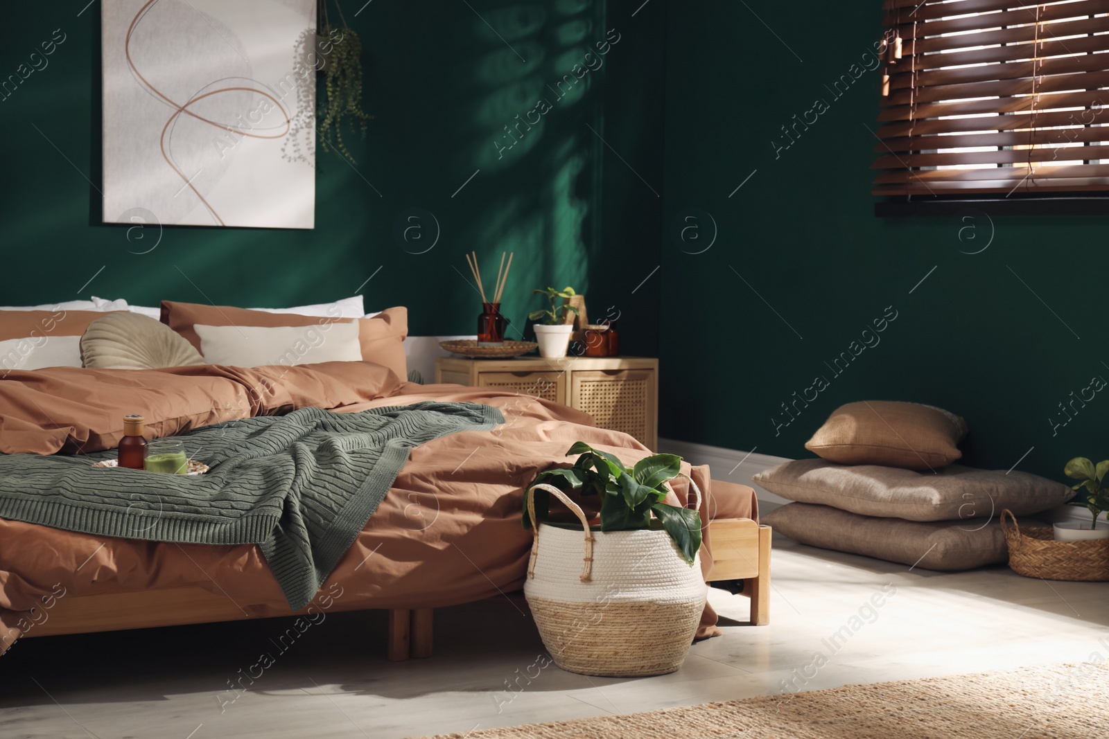 Photo of Stylish interior with large comfortable bed and potted plants