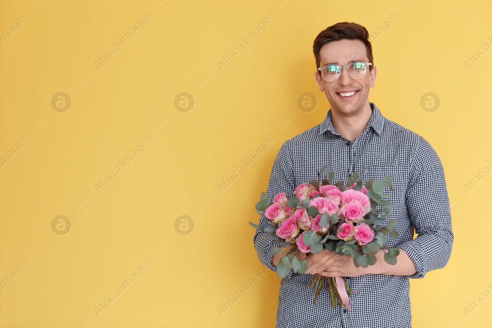 Photo of Male florist holding bouquet of beautiful flowers on color background