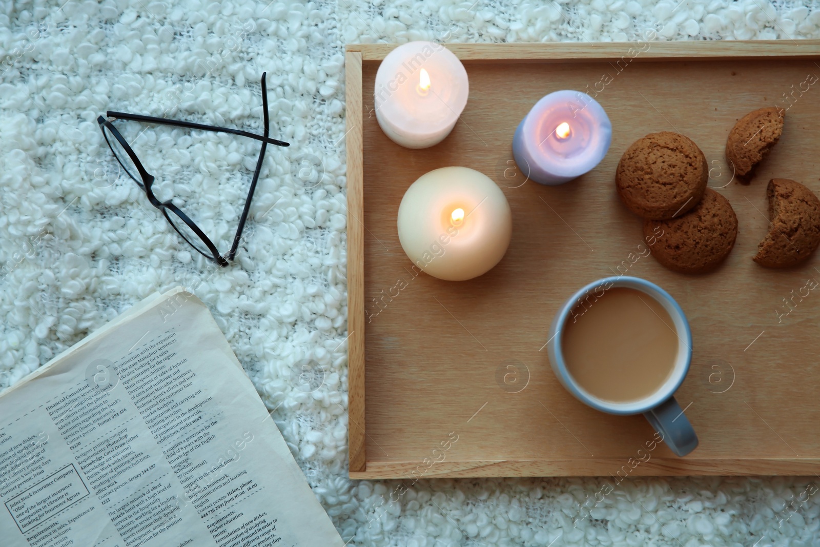 Photo of Flat lay composition with burning candles on soft fabric