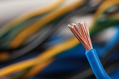Photo of Light blue electrical wire on blurred background, closeup. Space for text