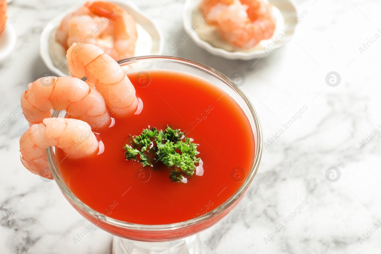 Photo of Glass with boiled shrimps and tomato sauce on light background