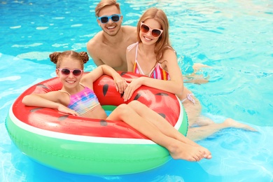 Photo of Happy family in pool on sunny day