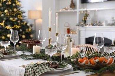 Photo of Christmas table setting with festive decor and dishware in living room