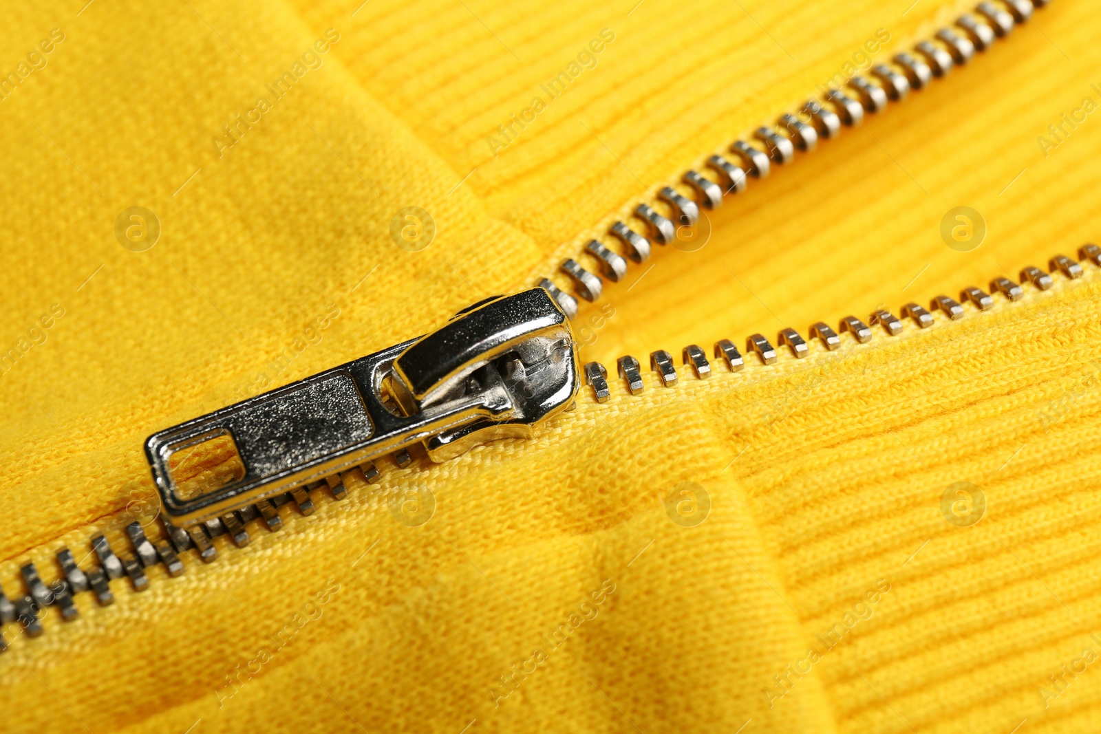 Photo of Yellow sweatshirt with zipper as background, closeup view